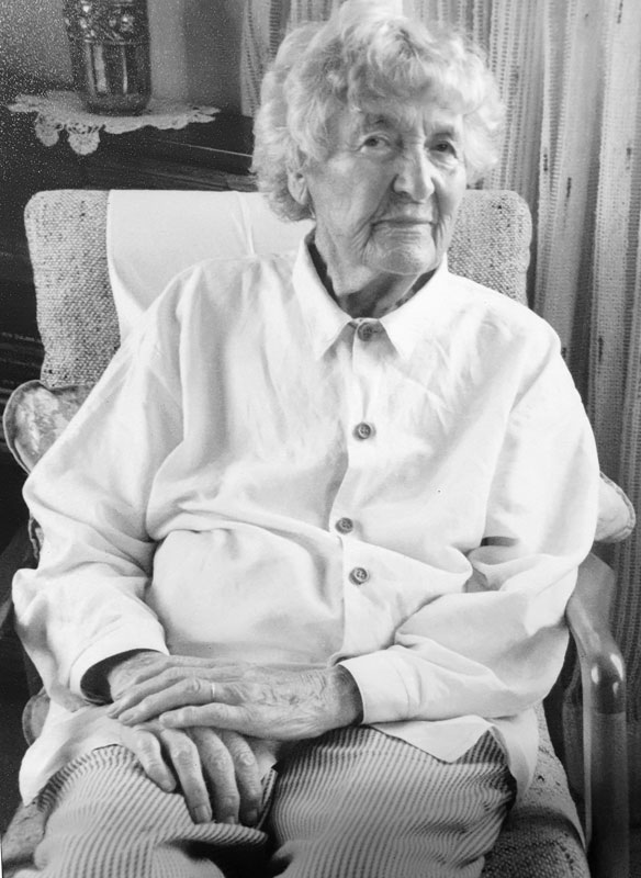 Mavis Davidson as an elderly woman, seated in an armchair. 