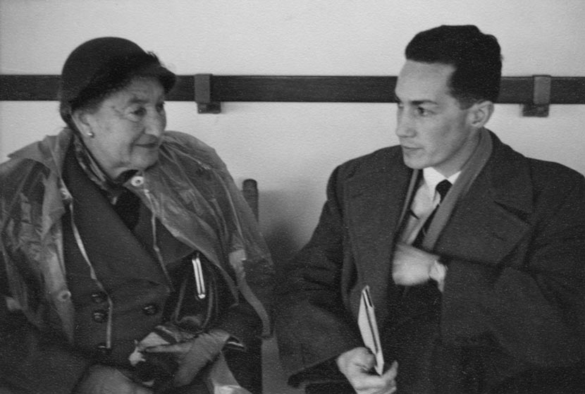 A middle-aged woman and a young man seated side by side in semi-formal clothing.