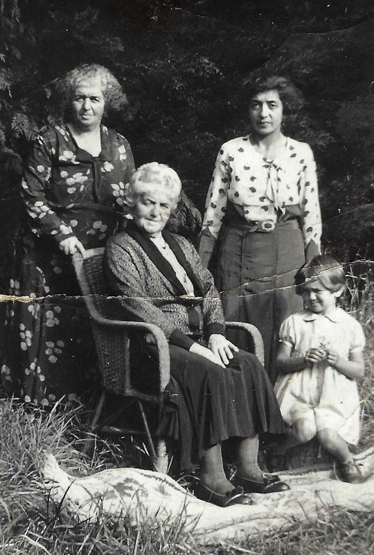 Mina, as a small child, with two older women and one young woman.