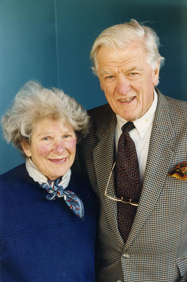An older man and woman standing side by side and smiling.