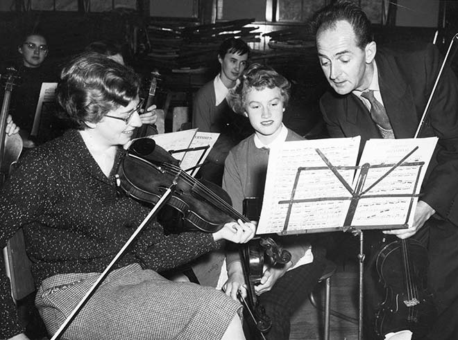 Vincent Aspey helps fellow violinists Olwyn Castle and Silvia Roberts, about 1954