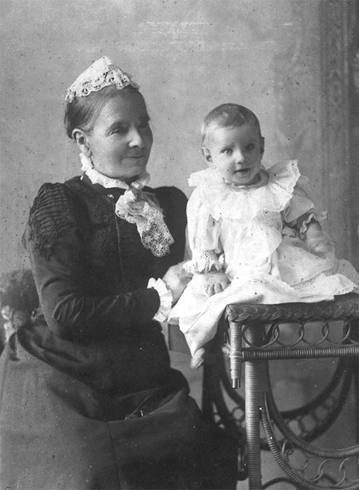 A photograph of Annie Schnackenberg seated with a baby