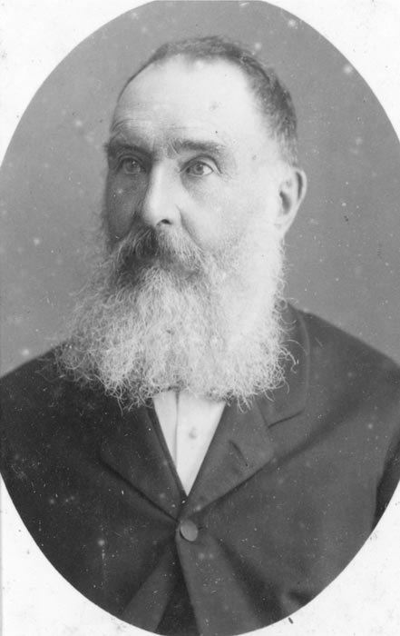 A head and shoulders portrait of a bearded, middle aged Pākehā man.
