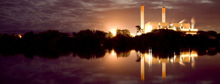 Huntly Power Station lit up at night with Waikato River in foreground