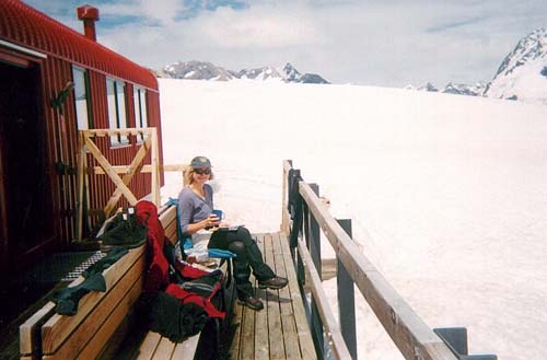 Woman sitting on deck if building on snow