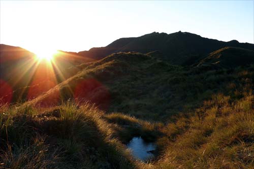 Sun peaking over distant hills