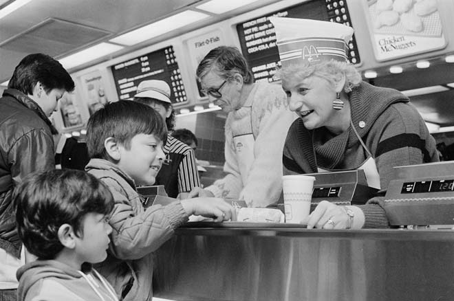 Woman serving kids at busy McDonald's