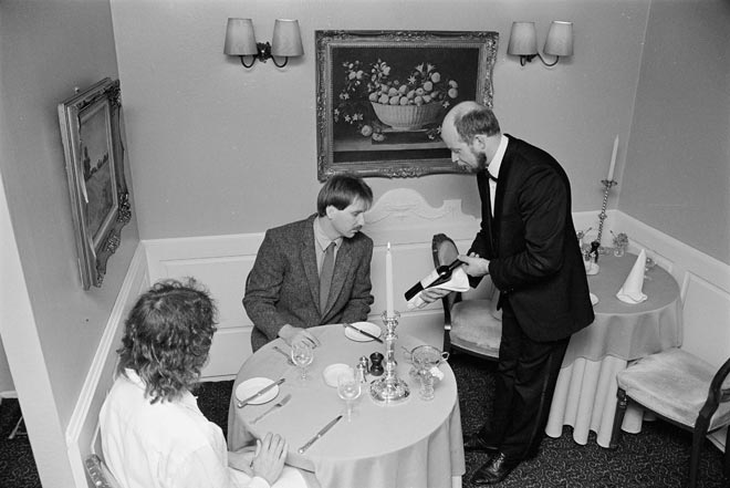Couple being served wine at restaurant