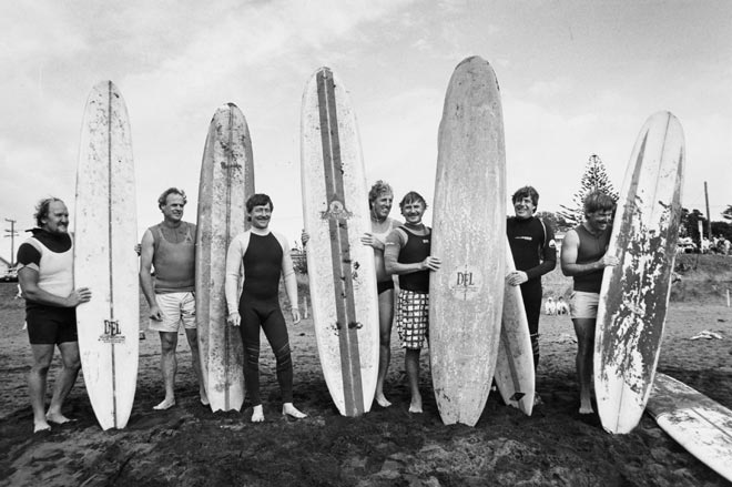Group of men holding surfboards on beach
