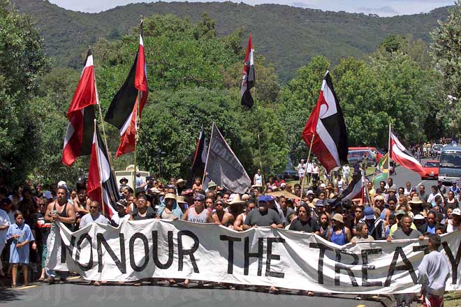 Protest march with Māori flags and Honour the Treaty banner