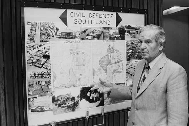 A man standing in front of a collection of images of flooding.