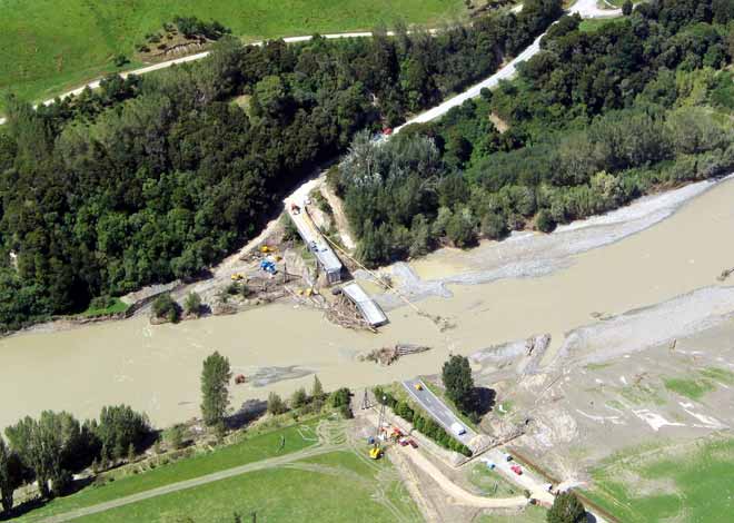 Aerial photo of a flooded river and broken bridge.