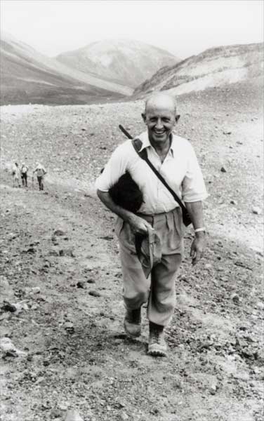 A man walks up a mountain. 