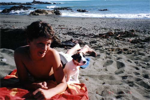 Man and small dog sunbathing on beach