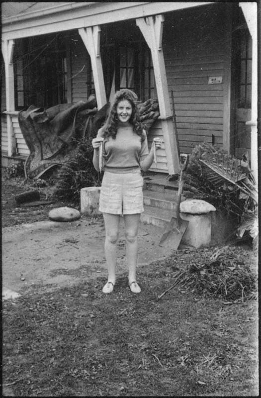 Woman in front of house holding two small fish