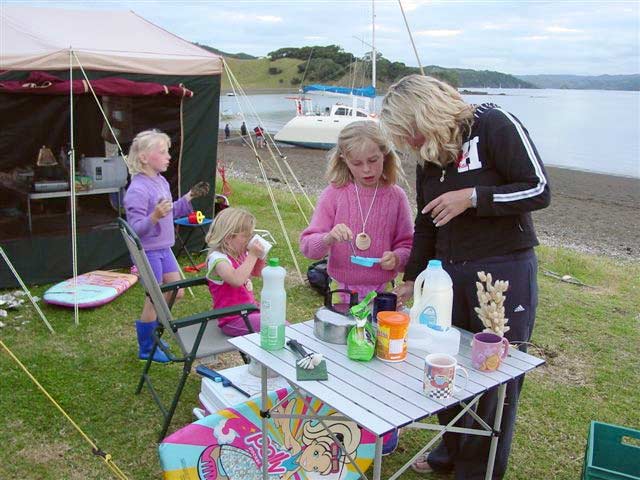 Mother with three young children at a camping site by the sea
