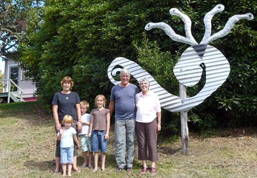 Family group in front of sculpture on lawn