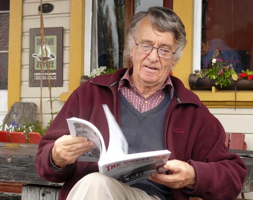 Man sitting on porch reading book titled 'The Great '08'