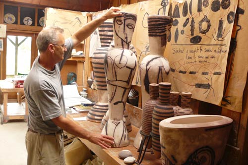 Man holding a large ceramic piece in workshop