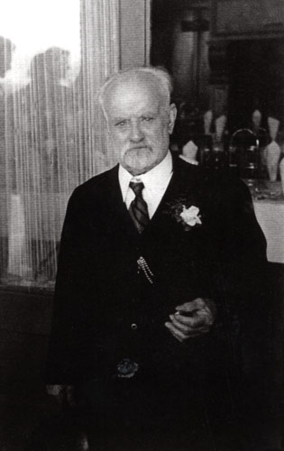 Man with grey hair and beard posing for photograph