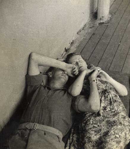 Couple sleeping on deck of ship