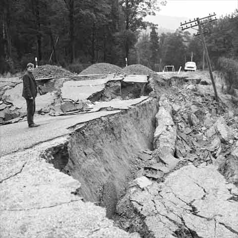 Man standing next to collapsed road