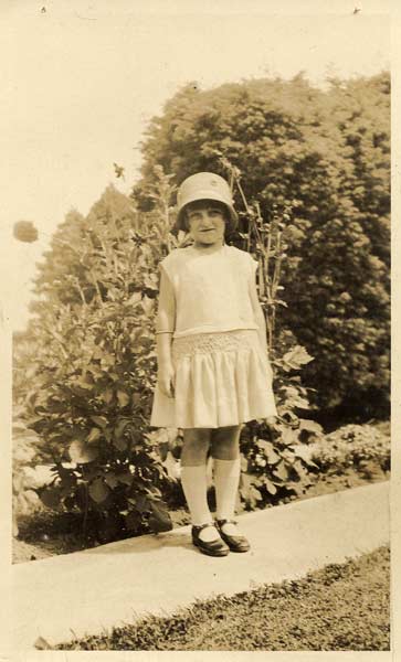 Young girl with hat standing on a path