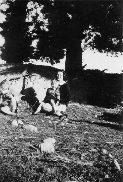 Woman and child sitting under trees