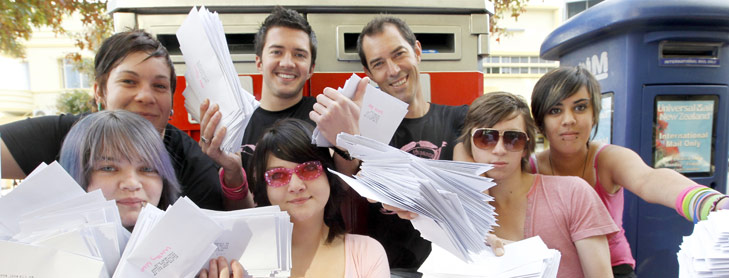 Group of people holding up bundles of voting papers