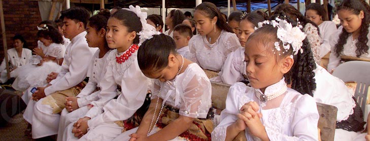 Kids in church in formal white costumes