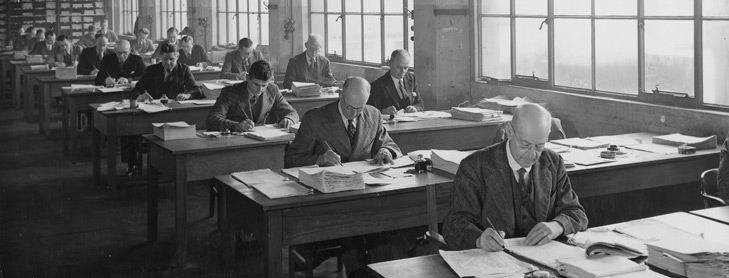 Men working at desks in early office