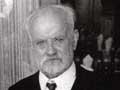 Man with grey hair and beard posing for photograph