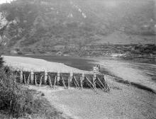 Temporary drying wall on side of river where people are standing