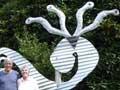 Family group in front of sculpture on lawn
