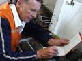 Man leaning on core samples making notes in notebook