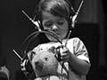 Boy and teddy bear listen to a crystal set, 1928