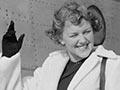 Woman waves as she boards a plane