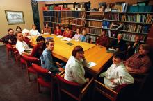 Staff around a table in a library looking up at camera
