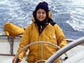 Woman steering boat in heavy seas