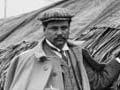 Māui Pōmare alongside a raupō whare at the Christchurch exhibition in 1906 or 1907