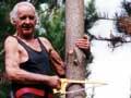 Man in black singlet against a tree