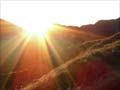 Sun peaking over distant hills