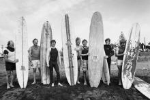 Group of men holding surfboards on beach
