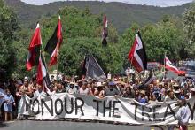 Protest march with Māori flags and Honour the Treaty banner