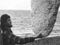 Man on beach holding piece of polystyrene