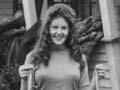 Woman in front of house holding two small fish