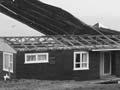 Roof of seaside house being blown off by he wind