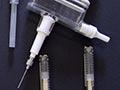 A photograph showing 11 plastic syringes of a variety of styles