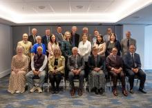 A group of men and women arranged in three rows for a photograph