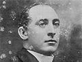 Man in sitting in chair dressed in priest clothing